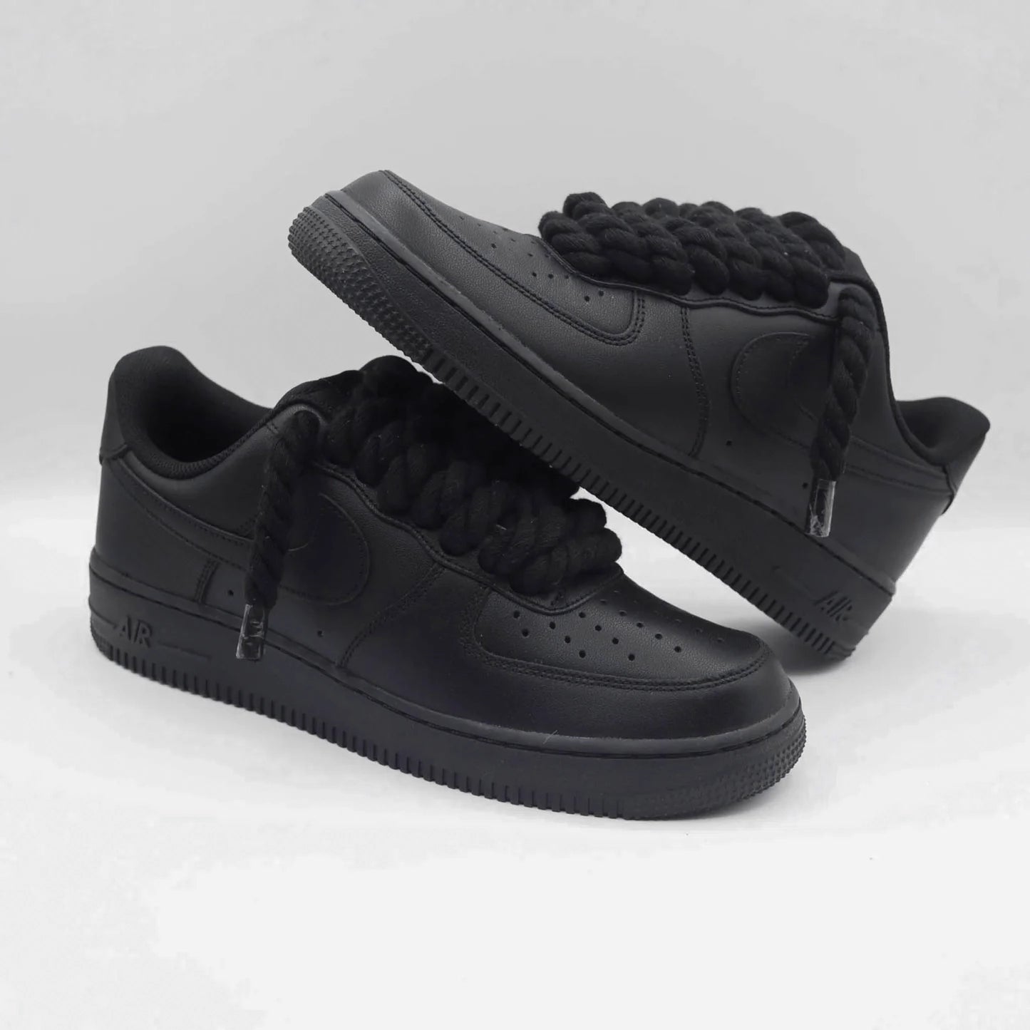 Čierne Nike Air Force 1 s čiernymi rope laces položené cez seba
