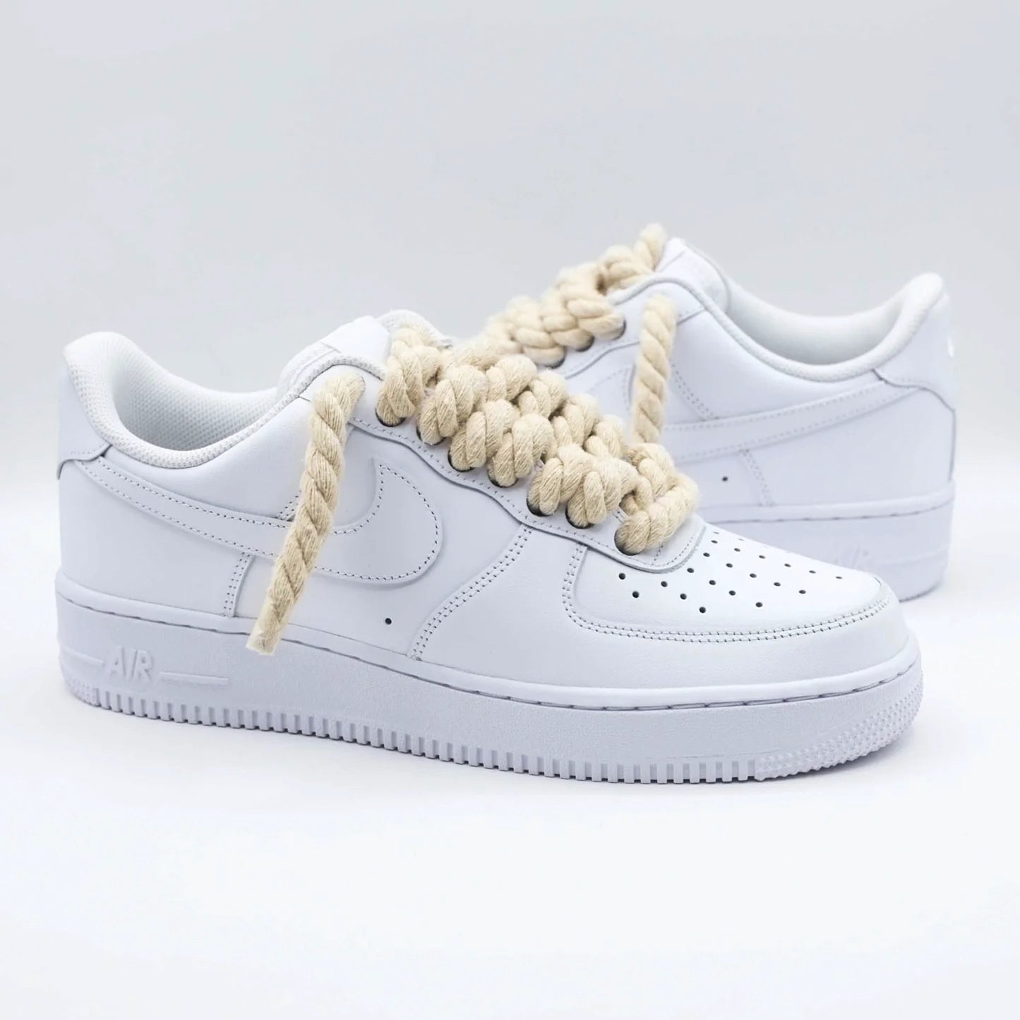 Bočný pohľad na biele Nike Air Force 1 s béžovými rope laces
